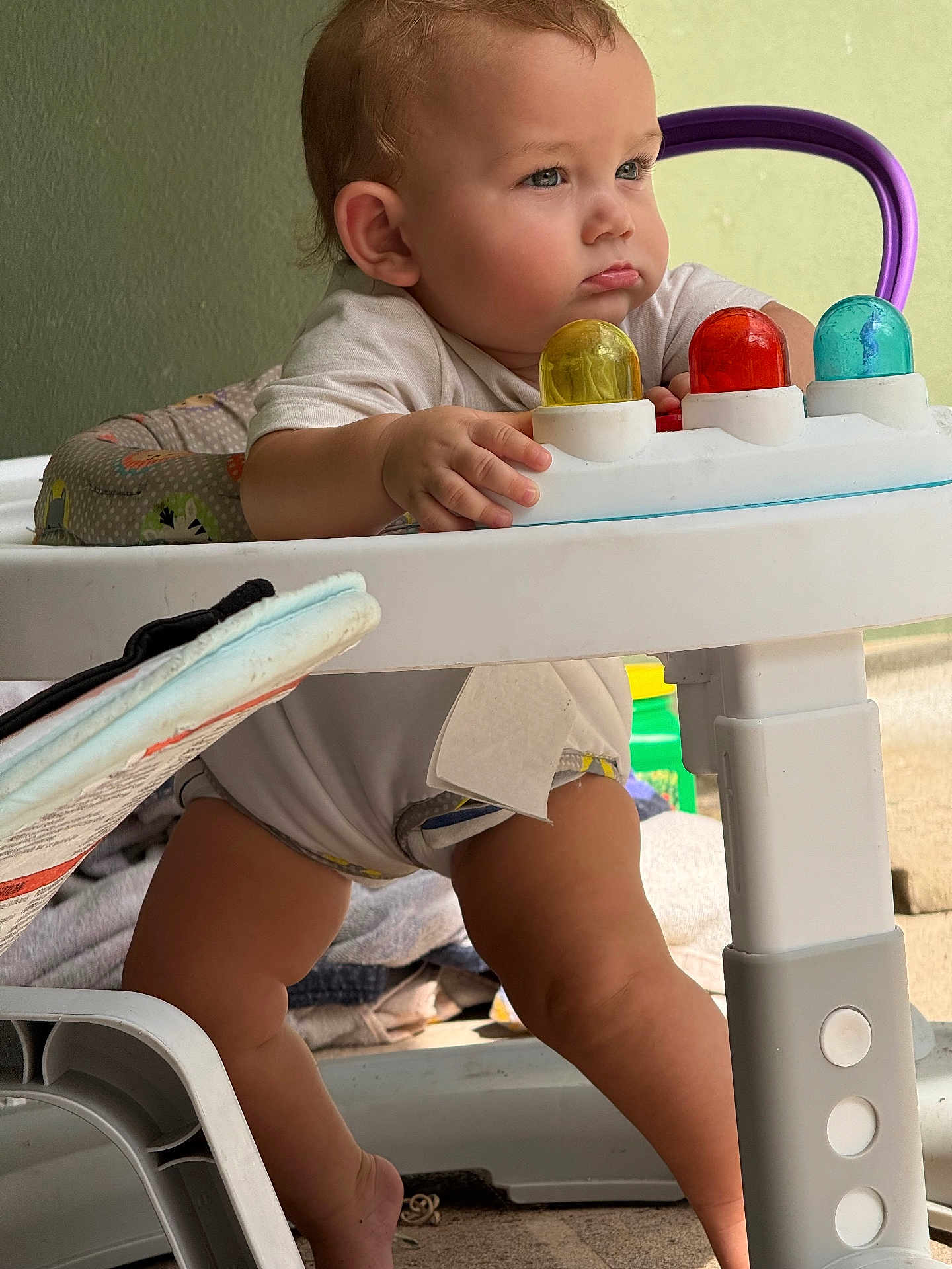Praxton is registered to the contest to win money with this photo: baby, child, closeup, colorful, concentration, cute, expression, footwear, furniture, hand, home, indoor, infant, legs, plastic, playtime, toy, walker, white, young_child