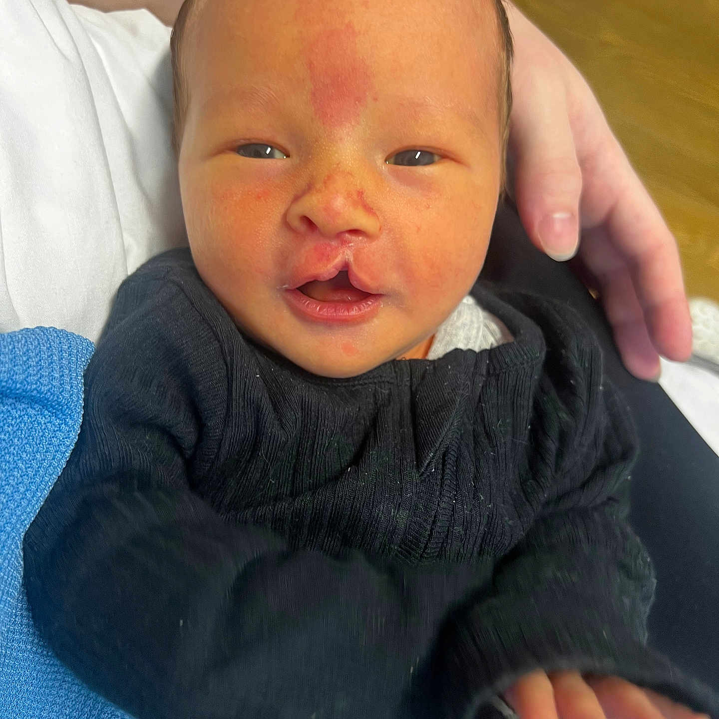 Rory is registered to the contest to win money with this photo: architecture, baby, bodypart, building, clothing, coat, face, finger, glove, hand, head, hospital, knitwear, mouth, newborn, pants, person, photography, portrait, sweater