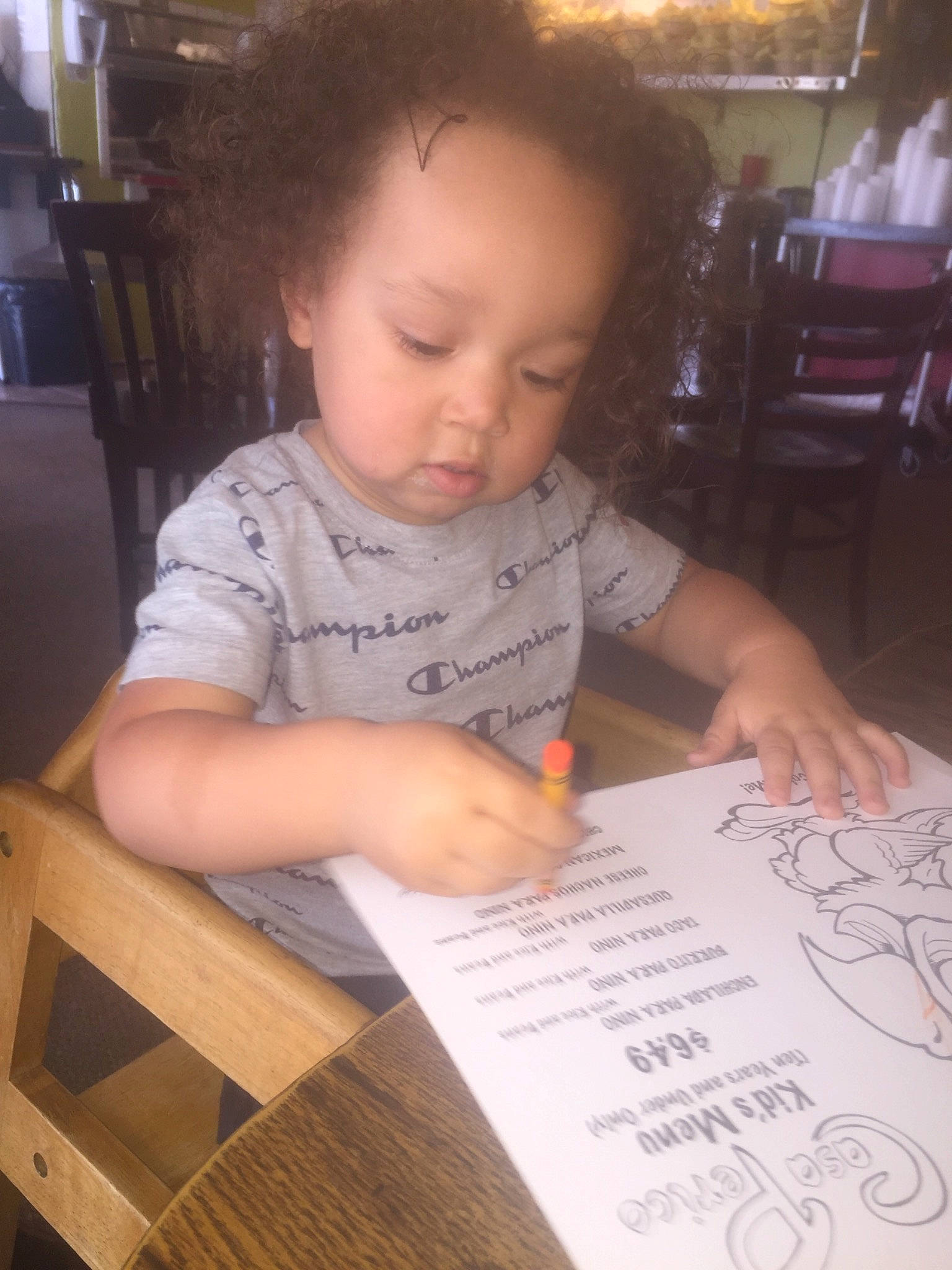 Kamarion is registered to the contest to win money with this photo: baby_toddler_clothing, chair, child, document, finger, furniture, hand, handwriting, homework, learning, nail, office_supplies, paper, paper_product, pen, person, stationery, toddler, writing, writing_implement