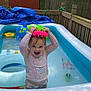 toddler, inflatable_pool, water_toy, backyard, child, swimsuit, summer, playful, smiling, water, toy, fence, plastic, outdoor, happy, splashing, colorful, sunlight, nature, fun