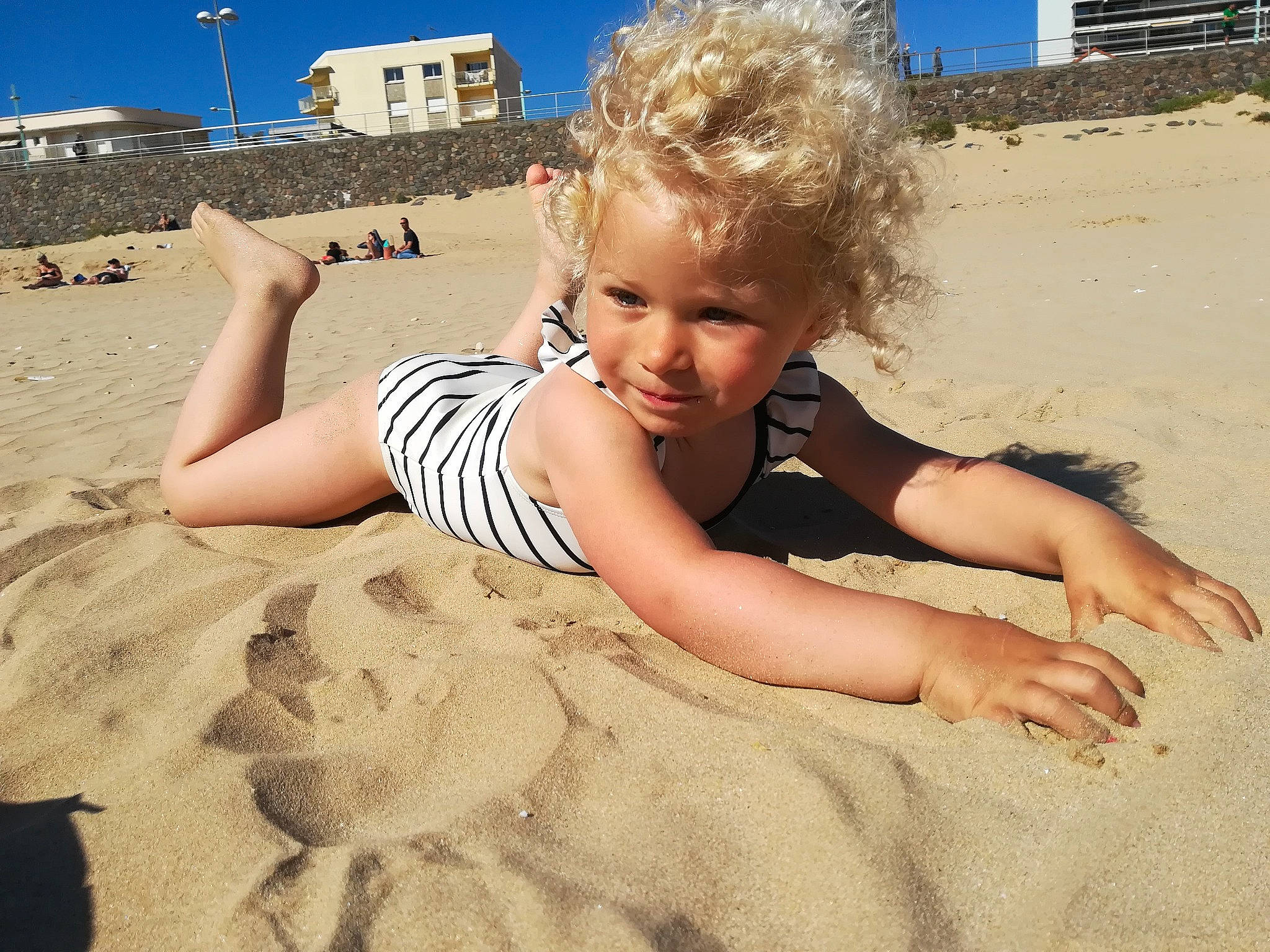 Adèle participe au concours pour gagner de l'argent avec cette photo : beach, blond, body_of_water, child, finger, fun, happy, human, human_leg, joy, landscape, leg, leisure, people_in_nature, people_on_beach, person, shore, sky, thigh, toddler