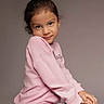 child, girl, portrait, pink_sweatshirt, plaid_skirt, smile, pose, studio, innocent, young, fashion, casual, cute, person, human, clothing, face, long_hair, background, sitting