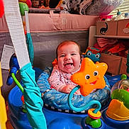 Aury joined the competition — help win amazing prizes! baby, smiling, infant, toy, activity_center, orange_star, blue, indoor, nursery, blanket, furniture, person, child, happy, play, face, clothing, room, cute, baby_supplies