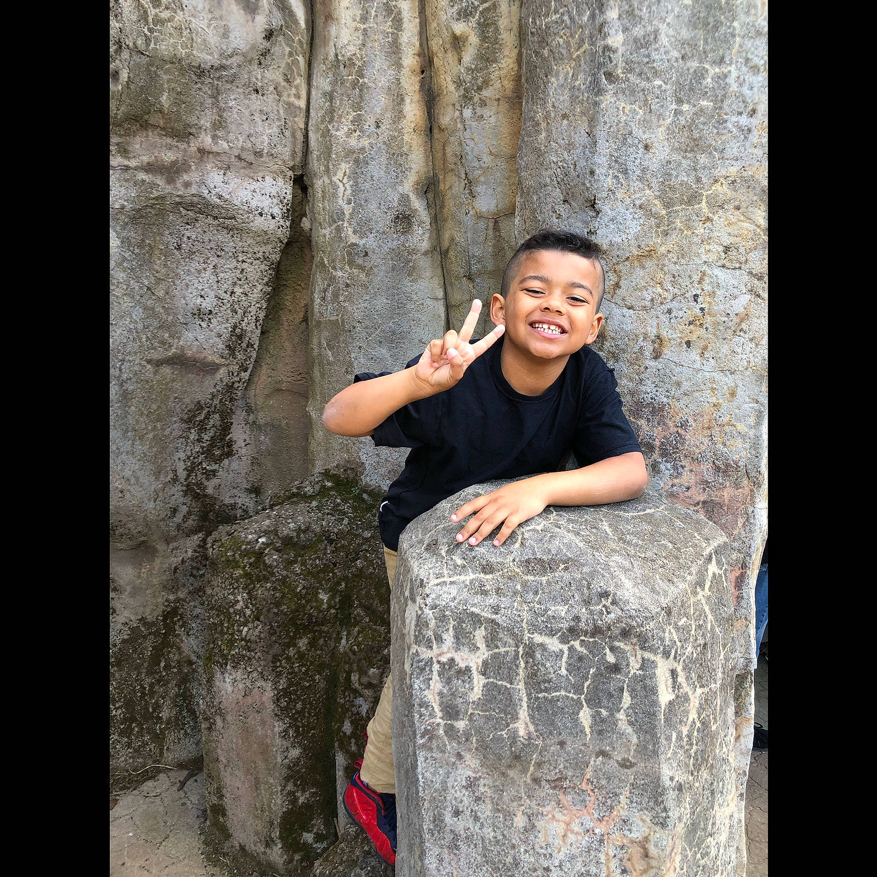 Dj joined the competition — help win amazing prizes! bedrock, child, flash_photography, fun, happy, joy, landscape, leisure, outcrop, people_in_nature, person, recreation, rock, sitting, smile, stone_wall, t_shirt, temple, tree, trunk