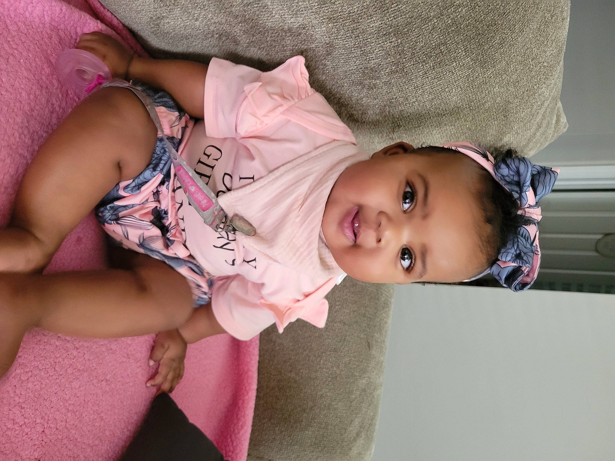 Ariella is registered to the contest to win money with this photo: baby, baby_toddler_clothing, cheek, dress, eye, face, facial_expression, fashion, head, human, human_body, joint, lip, mammal, person, pink, product, purple, skin, textile