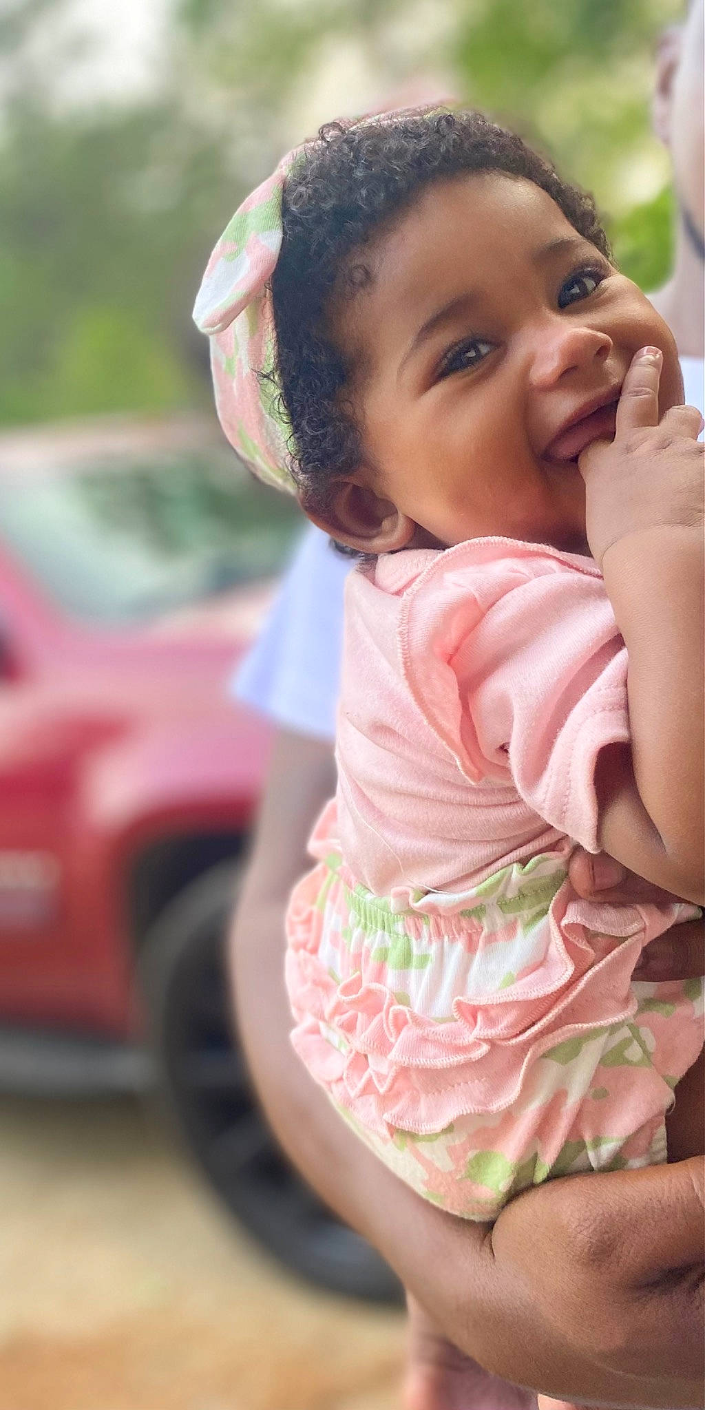 Kamilah is registered to the contest to win money with this photo: baby, baby_toddler_clothing, car, child, eye, fun, gesture, grass, happy, leisure, lip, person, pink, recreation, sitting, skin, smile, summer, tire, toddler