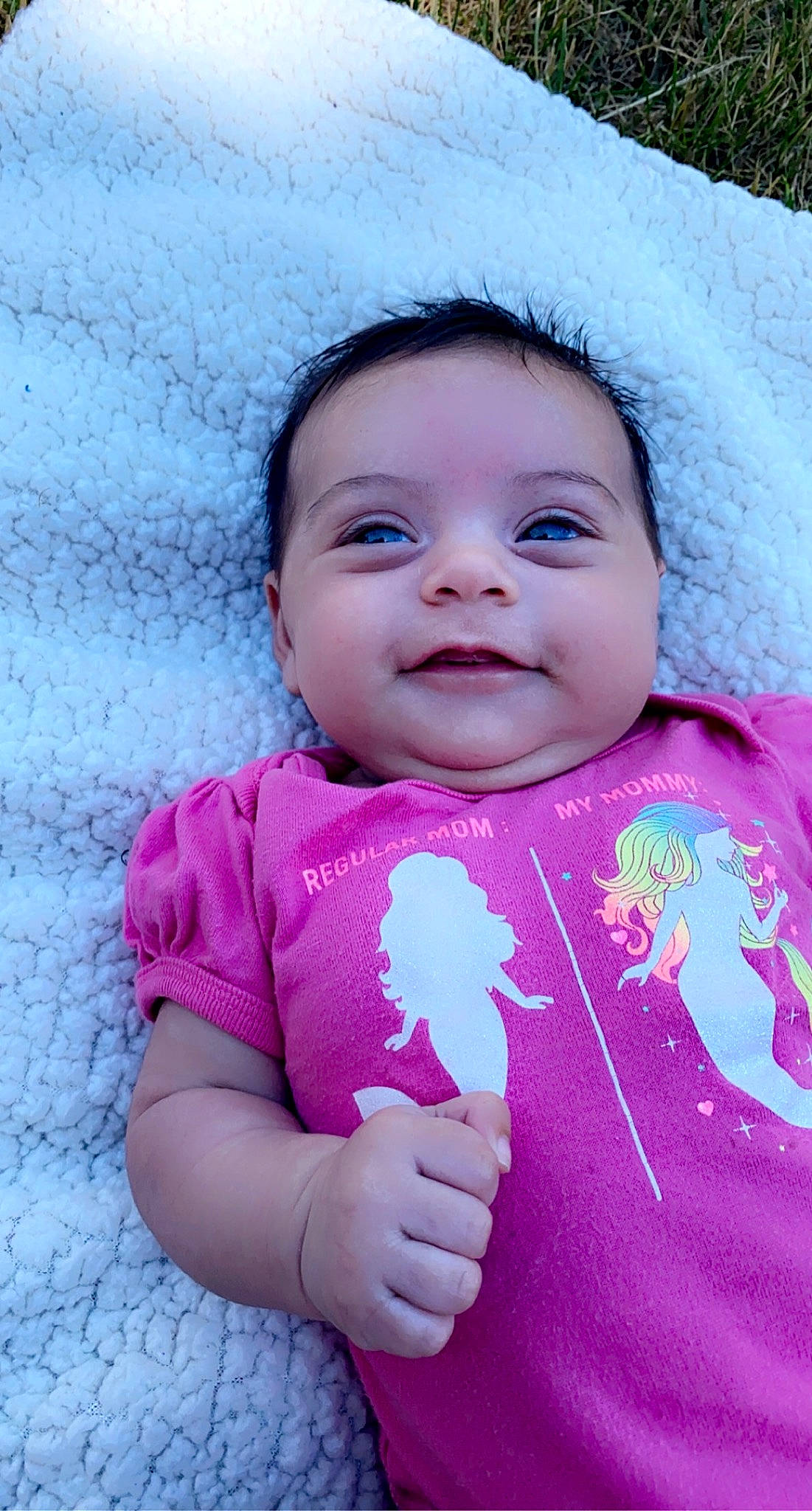 Giuliana is registered to the contest to win money with this photo: baby, baby_toddler_clothing, cheek, chin, face, gesture, grass, happy, iris, lip, magenta, mouth, nose, people_in_nature, person, pink, purple, skin, sleeve, smile