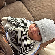 Evin joined the competition — help win amazing prizes! arm, baby, blanket, casual, closeup, couch, cozy, cute, face, hat, headwear, holding, indoor, infant, newborn, person, resting, soft, striped_clothing, toddler