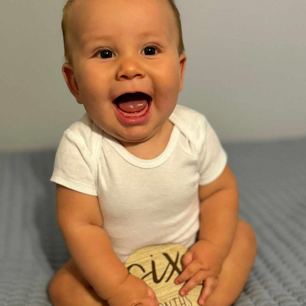Mateo is registered to the contest to win money with this photo: accessories, baby, babylaughing, bodypart, bracelet, clothing, face, finger, hand, happy, head, jewelry, laughing, newborn, person, photography, portrait, sitting, smile, t_shirt