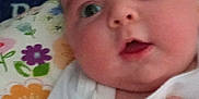 Rowan joined the competition — help win amazing prizes! baby, infant, face, hand, blanket, floral_pattern, clothing, cute, portrait, expression, wide_eyes, chubby_cheeks, indoor, soft, warmth, comfort, person, skin, fabric, closeup