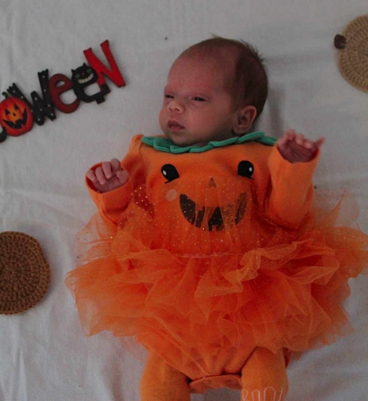 Isla-Rose joined the competition — help win amazing prizes! baby, infant, halloween, orange_clothing, pumpkin_costume, tulle_skirt, blanket, face, cute, holiday, festive, lying_down, costume, child, celebration, smile, decoration, holiday_theme, person, indoors