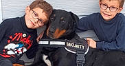 Orko a rejoint le concours — aidez-le/la à gagner de superbes lots ! animal, boy, casual_clothing, child, companionship, cuddling, cute, dog, family, friendship, glasses, happy, outdoor, pet, posing, protective, security_vest, smiling, wall, young