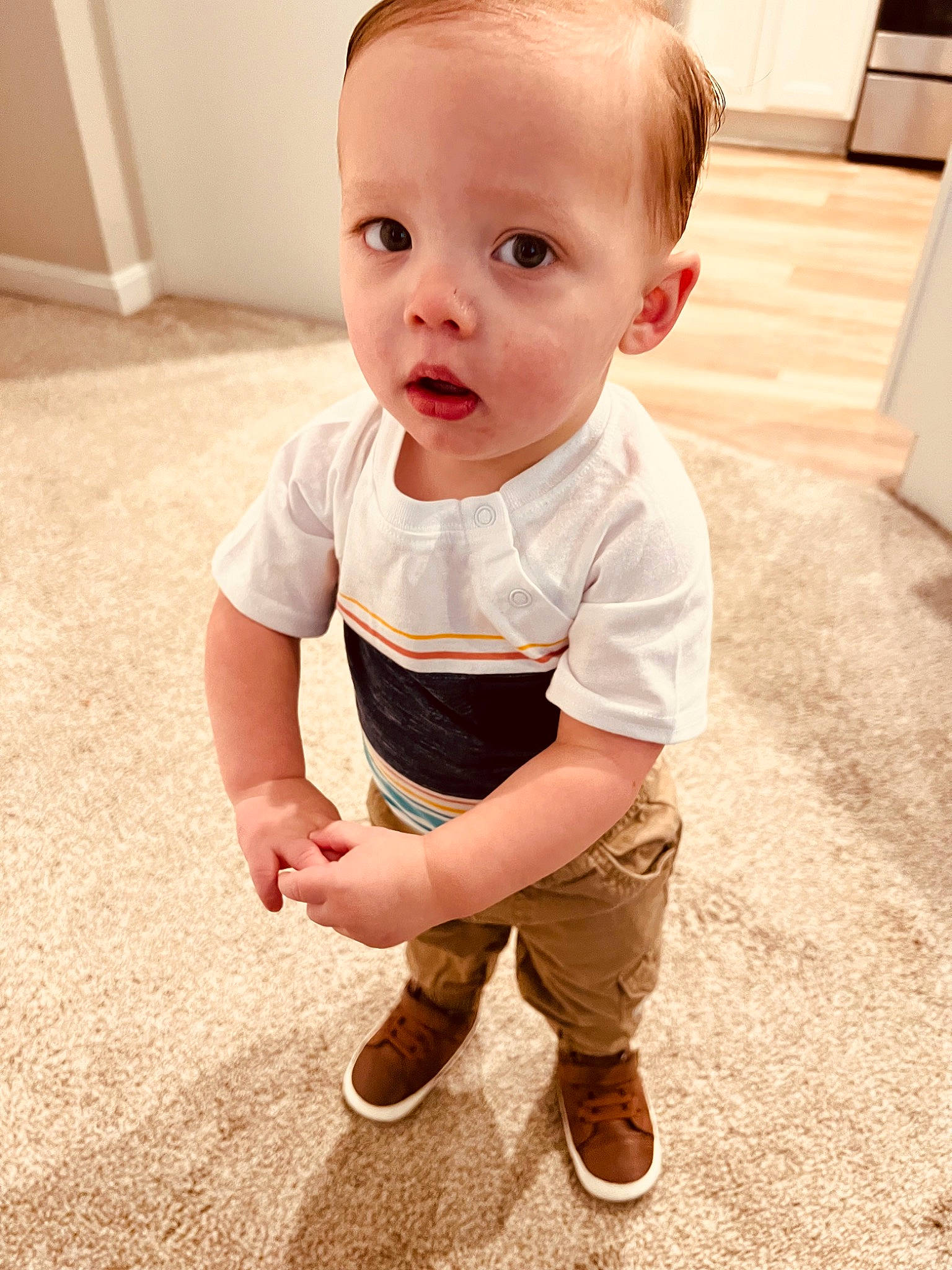 Lincoln is registered to the contest to win money with this photo: arm, baby, baby_toddler_clothing, cheek, child, eye, face, finger, floor, flooring, happy, head, knee, pattern, person, sitting, skin, sleeve, t_shirt, toddler