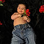 baby, bare_torso, black_background, blanket, child, cute, denim, face, flower_prop, hand, infant, jeans, lying_down, portrait, red_flower, rose, skin, smile, soft_texture, studio_style