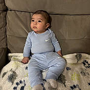 Ezra joined the competition — help win amazing prizes! baby, blanket, casual_clothing, cheeks, child, couch, cozy, eyes, gaze, hands, indoor, infant, living_room, nike_logo, onesie, portrait, seated, socks, sofa, soft_texture