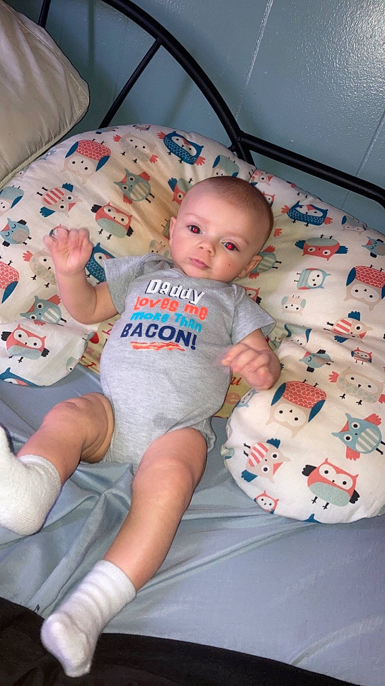 Brian Lee is registered to the contest to win money with this photo: baby, baby_toddler_clothing, carmine, cheek, child, comfort, finger, foot, fun, human_leg, knee, lap, leg, linens, mouth, person, sitting, skin, t_shirt, thigh