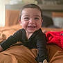 Danny joined the competition — help win amazing prizes! baby, smile, happy, infant, black_sweater, blanket, bed, indoors, cute, child, portrait, young, skin, face, hands, warm_colors, red_blanket, cozy, teeth, expression