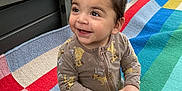 Danny is registered to the contest to win money with this photo: toddler, child, smiling, toy, truck, onesie, lion_king, blanket, colorful, indoor, happy, sitting, playtime, cute, infant, baby, young_child, person, bright, casual