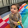 toddler, child, smiling, toy, truck, onesie, lion_king, blanket, colorful, indoor, happy, sitting, playtime, cute, infant, baby, young_child, person, bright, casual