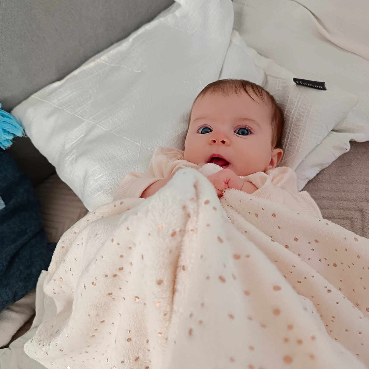 Leonida Ana participe au concours pour gagner de l'argent avec cette photo : baby, bed, blanket, blue_eyes, child, clothing, comfort, cozy, cute, expression, face, indoors, infant, looking_up, lying_down, pillow, portrait, resting, skin, soft