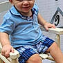 toddler, child, smiling, blue_shirt, plaid_shorts, white_shoes, chair, wooden_chair, indoor, height_chart, happy, portrait, cute, baby, shorts, footwear, sitting, person, casual_clothing, light_hair