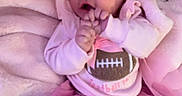 Everleigh is registered to the contest to win money with this photo: baby, infant, child, portrait, pink, bow, headband, tutu, dress, football, bib, smiling, sitting, indoors, bed, blanket, nursery, hands, face, photography