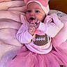 baby, infant, child, portrait, pink, bow, headband, tutu, dress, football, bib, smiling, sitting, indoors, bed, blanket, nursery, hands, face, photography