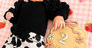 Everleigh is registered to the contest to win money with this photo: baby, black_clothing, blanket, bow, child, cow_print, headband, indoor, infant, lying_down, milestone, pacifier, pants, picnic_blanket, pink, portrait, ruffles, strawberry, two_months, wooden_sign