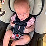 baby, infant, child, sleeping, car_seat, harness, pink_outfit, checked_clothing, portrait, face, closed_eyes, seated, vehicle_interior, padded_seat, safety_belt, baby_clothing, legs, feet, cozy, travel