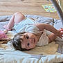 baby, infant, play_mat, toy, floor, curious, clothing, soft_toys, wooden_floor, child, indoors, crawling, cute, person, baby_girl, white_clothing, playtime, expression, skin, hair