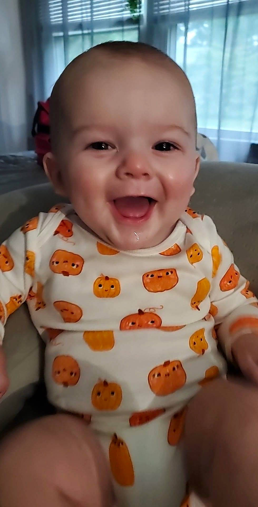 Jayce is registered to the contest to win money with this photo: baby, baby_laughing, baby_products, baby_toddler_clothing, bib, cheek, child, facial_expression, fun, happy, infant_bodysuit, mouth, nose, orange, person, product, sitting, skin, sleeve, smile