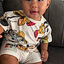 Shiye is registered to the contest to win money with this photo: baby, child, mickey_mouse, cartoon_clothing, couch, indoor, smile, cute, sitting, person, funny_clothing, shorts, tshirt, furniture, young_child, portrait, happy, skin, legs, hand