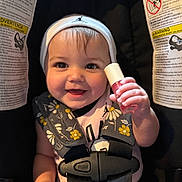 Brynleigh joined the competition — help win amazing prizes! baby, child, smiling, car_seat, seatbelt, beanie, infant, cute, holding_object, pink, bottle, floral_pattern, happy, portrait, indoor, person, young_child, closeup, headwear, safety