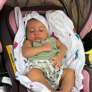 Evanni joined the competition — help win amazing prizes! baby, infant, car_seat, blanket, headband, green_top, floral_clothing, sleepy, cute, infant_girl, child, resting, seat, soft_fabric, indoors, person, newborn, adorable, comfortable, peaceful