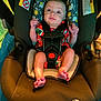 baby, infant, car_seat, child, seatbelt, floral_pattern, clothing, foot, barefoot, straps, sitting, indoor, cute, person, newborn, head_support, red, black, blue, warning_label