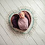 baby, newborn, wrapped, blanket, heart_shaped_bowl, syringes, circle, white_floor, wooden_floor, purple_blanket, headband, infant, portrait, studio_photo, medical_theme, swaddled, cute, small, indoors, artistic