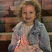 Kiana a rejoint le concours — aidez-le/la à gagner de superbes lots ! toddler, child, smiling, curly_hair, flower_hair_clip, denim_jacket, striped_dress, pacifier_clip, stairs, outdoor, night, happy, cute, person, portrait, sitting, young_child, clothing, fashion, accessory