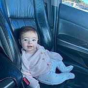 Alahia is registered to the contest to win money with this photo: baby, child, infant, smiling, portrait, car, vehicle, car_seat, seated, sweater, pants, clothing, blue, indoors, automotive, leather, window, daylight, face, happy