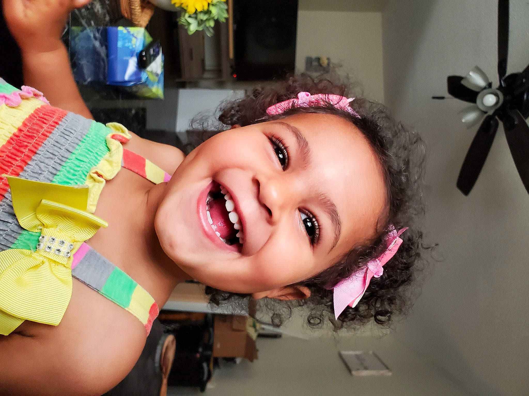 Jasmine is registered to the contest to win money with this photo: black_hair, ceiling_fan, cheek, ear, eyebrow, eyelash, face, happy, iris, jaw, joy, lip, mechanical_fan, mouth, neck, nose, person, pink, plant, skin