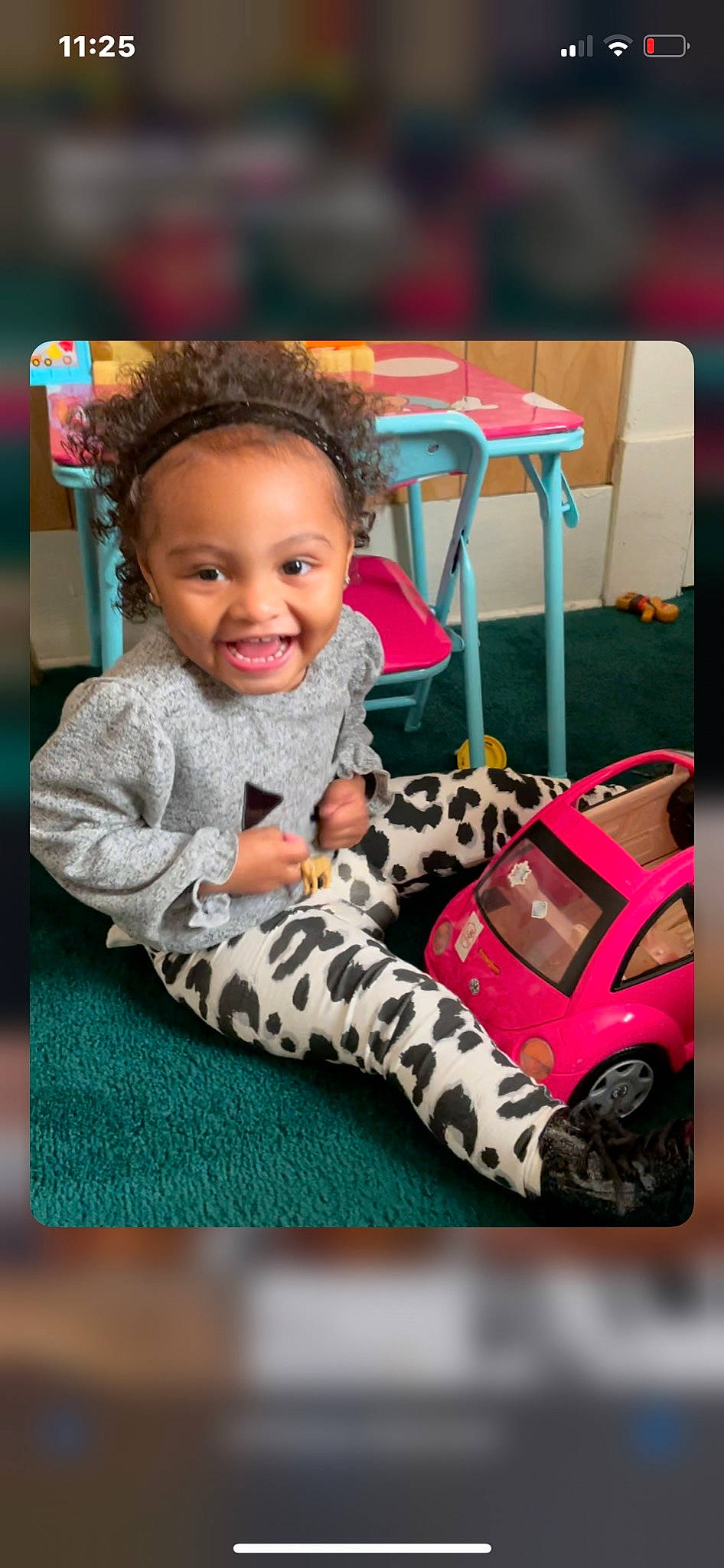 Millie is registered to the contest to win money with this photo: chair, child, electronic_device, eye, flooring, fun, hair, hand, happy, head, leisure, pattern, person, product, sitting, smile, technology, textile, toddler, toy