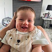 Lenny joined the competition — help win amazing prizes! baby, smiling, infant, child, cute, happy, face, portrait, clothing, overalls, bear_design, person, indoor, living_room, furniture, hand, skin, head, short_hair, comfort