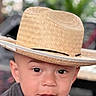 toddler, child, hat, straw_hat, face, eyes, mouth, expression, portrait, cute, indoor, blurred_background, curious, young_child, headwear, person, closeup, skin, eyebrows, casual_clothing