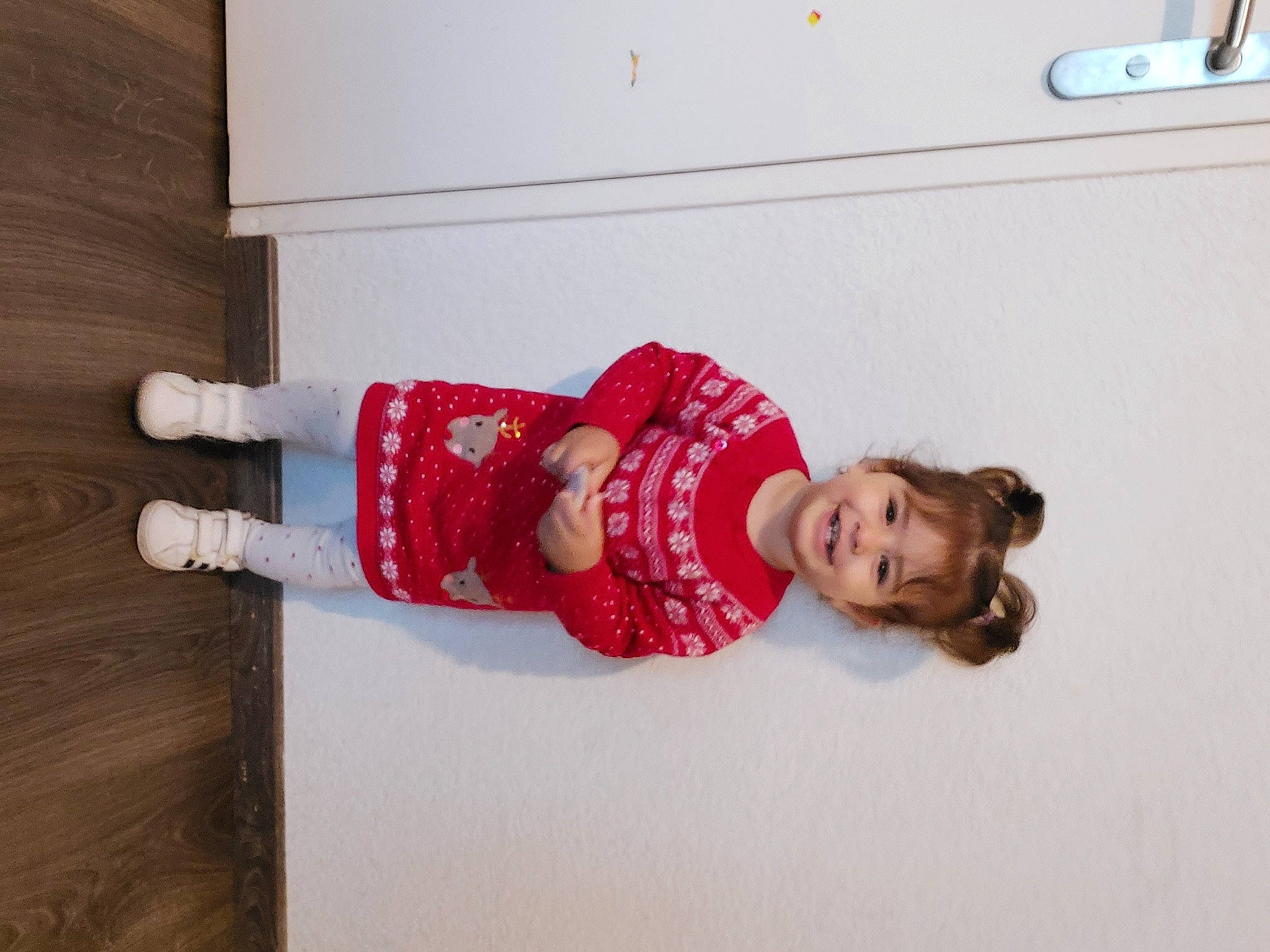 Emma-anastasia participe au concours pour gagner de l'argent avec cette photo : baby_toddler_clothing, child, comfort, floor, flooring, fun, happy, hardwood, human_leg, joy, knee, linens, pattern, person, room, sleeve, smile, sock, thigh, toddler