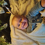 Maëlan participe au concours pour gagner de l'argent avec cette photo : baby, bear_design, blanket, blue_clothing, christmas_lights, cozy, cute, decorations, face, festive, greenery, hand, happy, holiday, indoors, infant, portrait, smiling, soft_texture, star_ornament