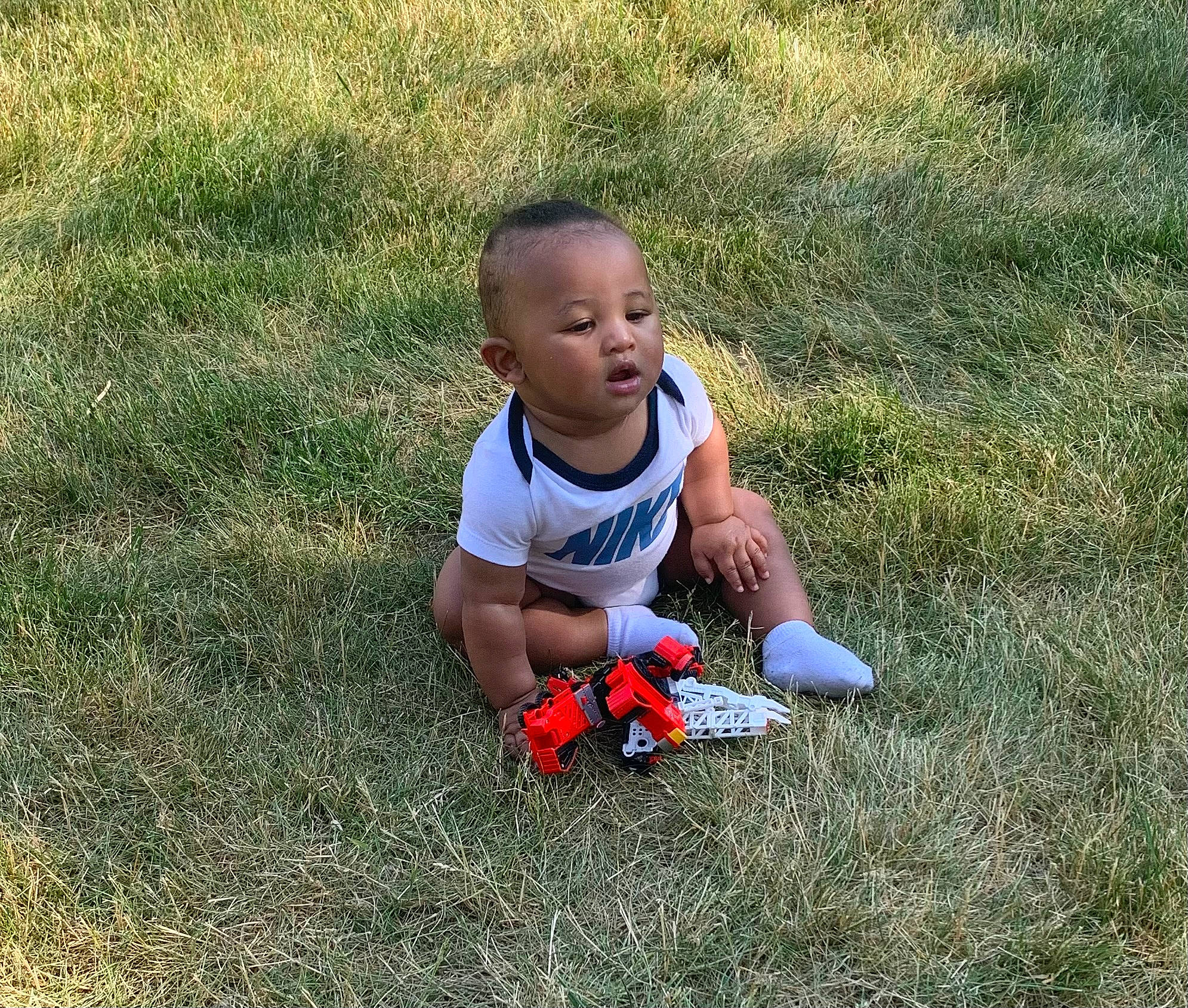 Nori is registered to the contest to win money with this photo: baby, baby_toddler_clothing, ball, carmine, child, flooring, fun, grass, grassland, happy, lawn, leisure, people_in_nature, person, play, player, recreation, sitting, soil, toddler