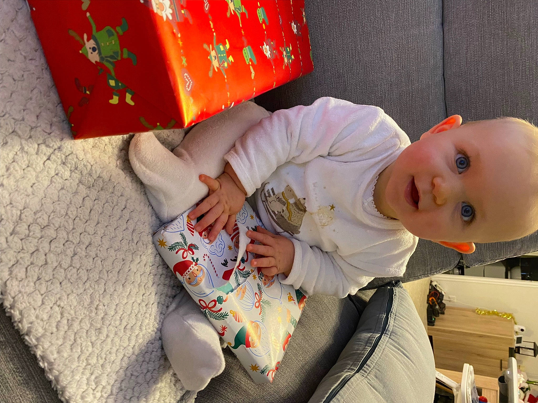 Mila participe au concours pour gagner de l'argent avec cette photo : baby, baby_products, baby_toddler_clothing, carmine, child, comfort, foot, fun, happy, human_leg, linens, orange, pattern, peach, person, room, sitting, sleeve, smile, thigh