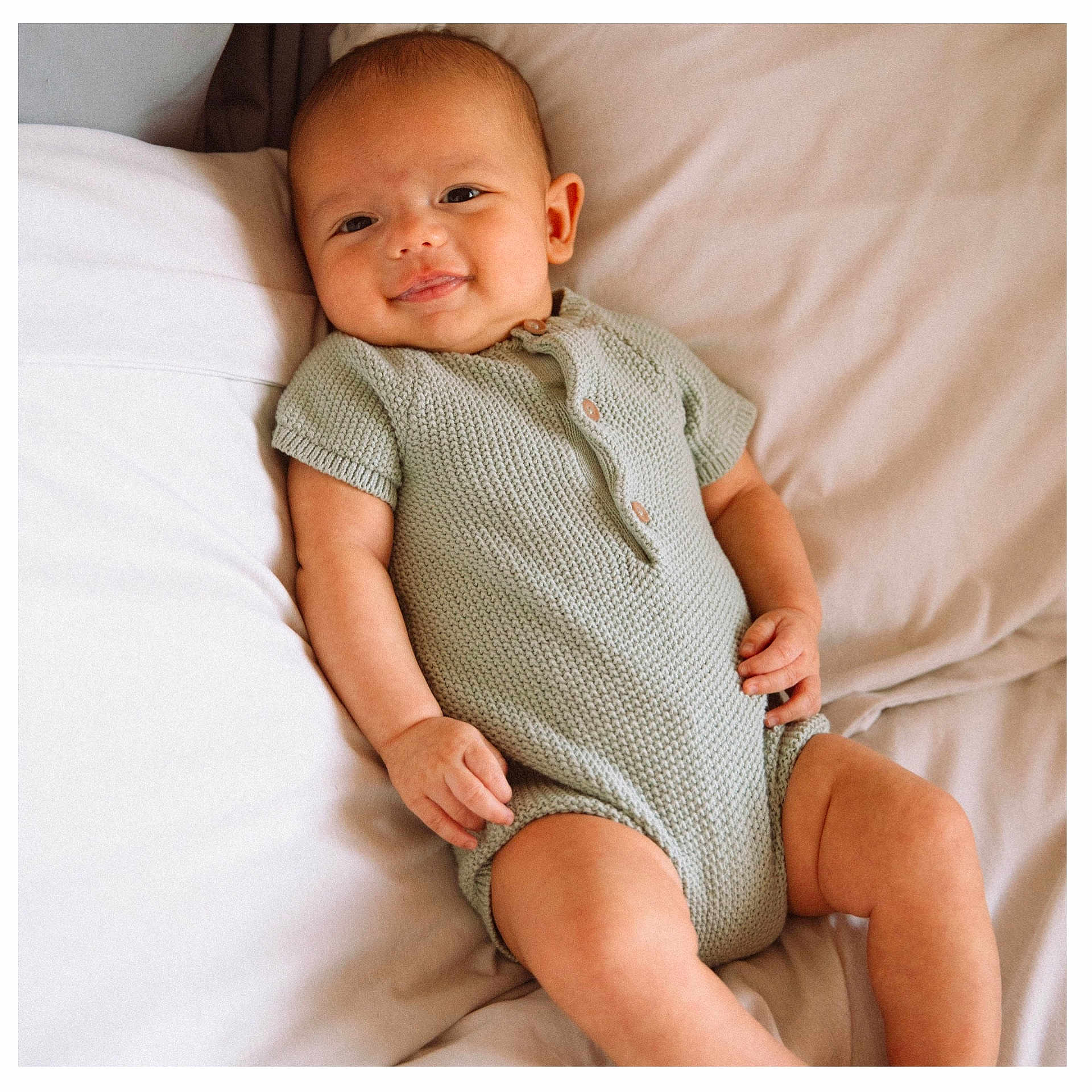 Asher is registered to the contest to win money with this photo: baby, babylaughing, bodypart, clothing, couch, cushion, face, finger, furniture, hand, happy, head, homedecor, newborn, person, photography, portrait, sitting, sleeve, smile
