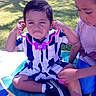 Aries is registered to the contest to win money with this photo: child, children, outdoor, grass, tree, toy, stethoscope, playing, funny_face, striped_clothing, sneakers, picnic_blanket, sunlight, park, greenery, siblings, casual_clothing, summer, happy, cute