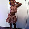 Zyair is registered to the contest to win money with this photo: child, girl, portrait, standing, smiling, peace_sign, colorful_hair_accessories, braids, pink_outfit, heart_pattern, skirt, sleeveless_top, shoes, socks, indoor, wardrobe, carpet, fashion, posing, happy