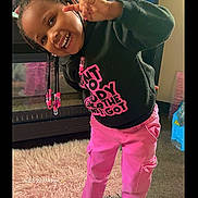 Zyair joined the competition — help win amazing prizes! child, smiling, indoor, portrait, braids, beads, peace_sign, black_sweatshirt, pink_pants, casual_clothing, standing, playful, happy, face, teeth, living_room, fuzzy_rug, water_bottle, furniture, photography